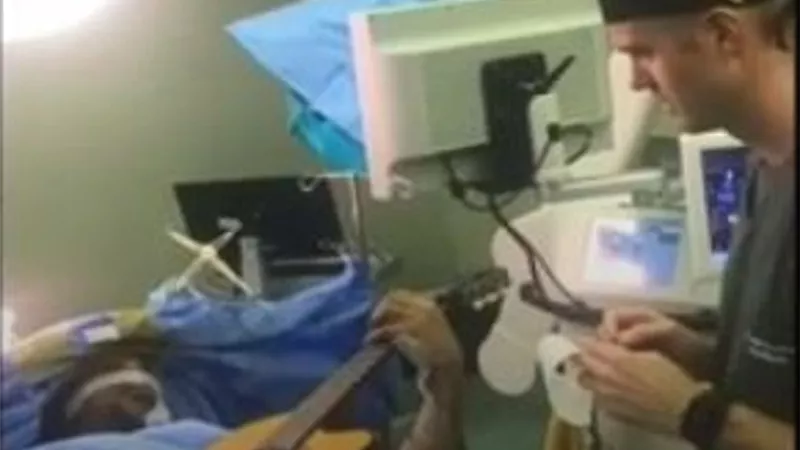 فنان يعزف على الجيتار أثناء خضوعه لجراحة بالمخ