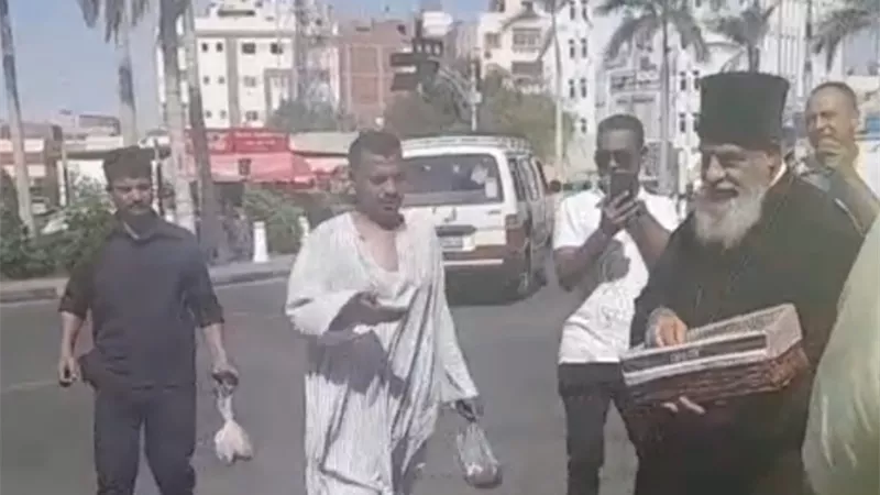 راعي الكنيسة الكاثوليكية يوزع حلوى المولد على المواطنين بالغردقة