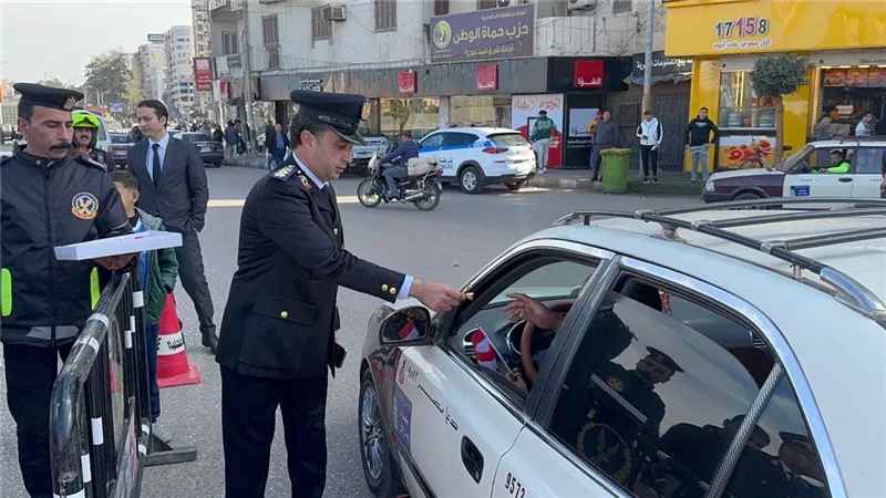 مرور الدقهلية توزع الورود و الاعلام علي المواطنين بالشوارع