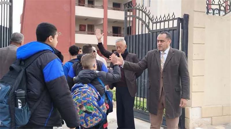 مدير مدرسة يستقبل التلاميذ أمام المدرسة ويهنئهم ببدء التيرم الثان