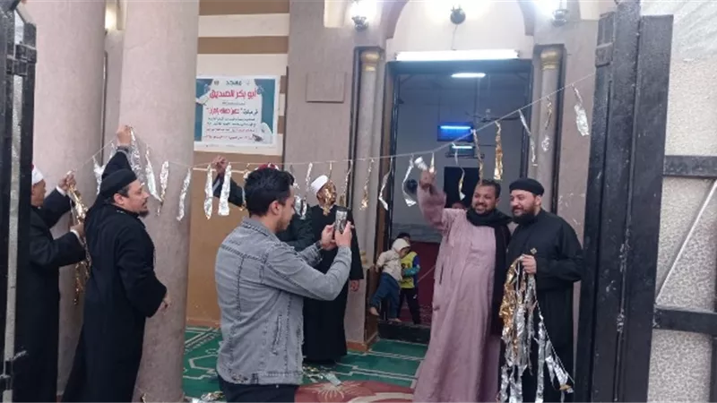 قساوسة وشيوخ يعلقون زينة رمضان بمسجد أبو بكر الصديق في قوص.. صور