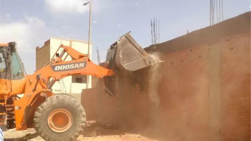 سوهاج الجديدة يزيل مبنى مخالف ويصادر خامات ومعدات البناء.. بالصور