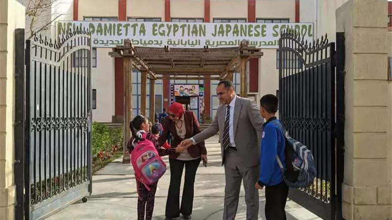 مدير مدرسة يستقبل التلاميذ أمام البوابة لتهنئتهم بالعيد