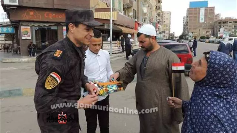 رجال الشرطة يوزعون ورود وحلويات احتفالا بعيدها في الإسماعيلية.صور