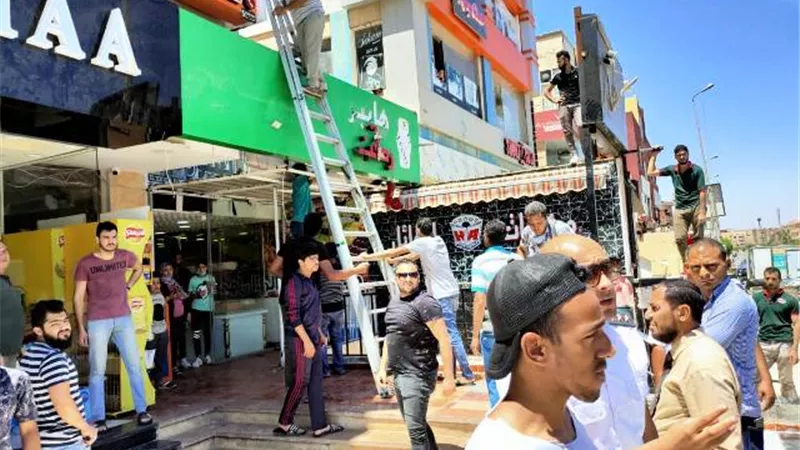 جهاز القاهرة الجديدة يزيل إعلانات المولات والمحلات المخالفة بالتعاون مع الشرطة.. بالصور