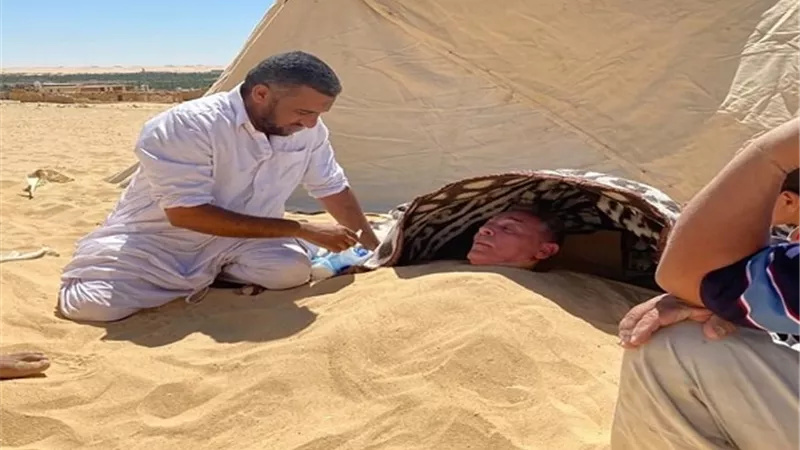 شاهد.. محمود حميدة يدفن نفسه فى رمال واحة 