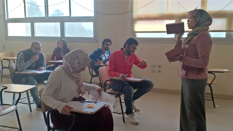 استاذة باعلام جامعة جنوب الوادى توزع الشيكولاته على الطلاب اثناء الامتحانات