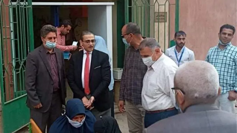 رئيس لجنة انتخابية يساعد سيدة من ذوي الاحتياجات الخاصة في الإدلاء بصوتها في شبرا