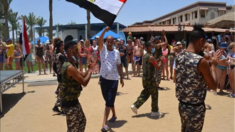 سائحون يرتدون الزي العسكرى ويرفعون صور السيسى احتفالا بثورة ٣٠ يونيو