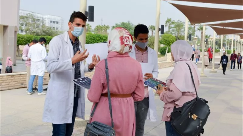 كلية الصيدلة جامعة حلوان تنظم حملة للتوعية بتطعيم كورونا.. بالصور