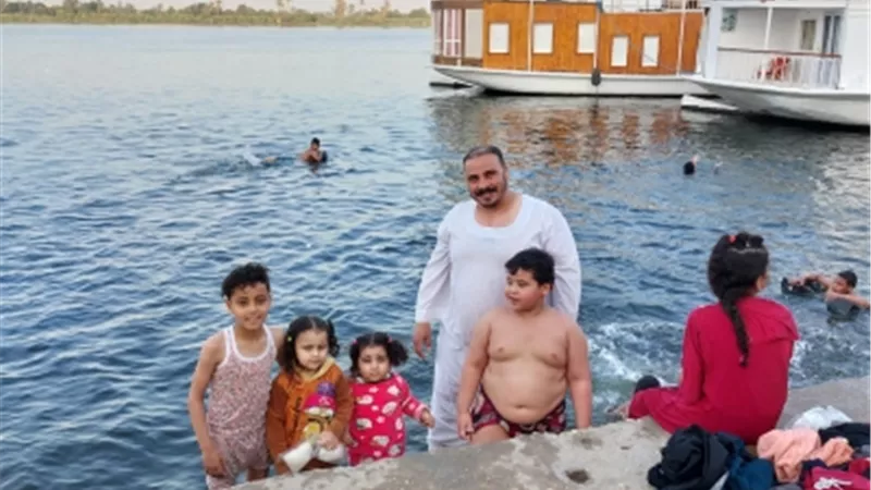 أهالي إسنا جنوب الأقصر يهربون من حرارة الطقس إلى النيل