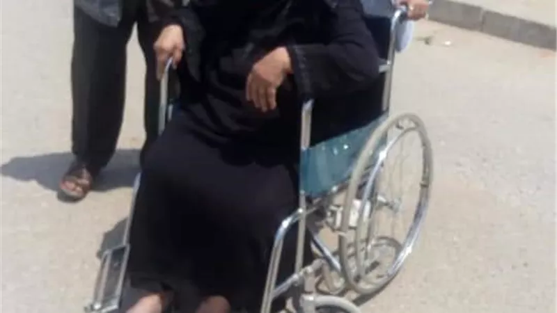 مسنة تدلي بصوتها على كرسي متحرك بإحدى لجان العاشر