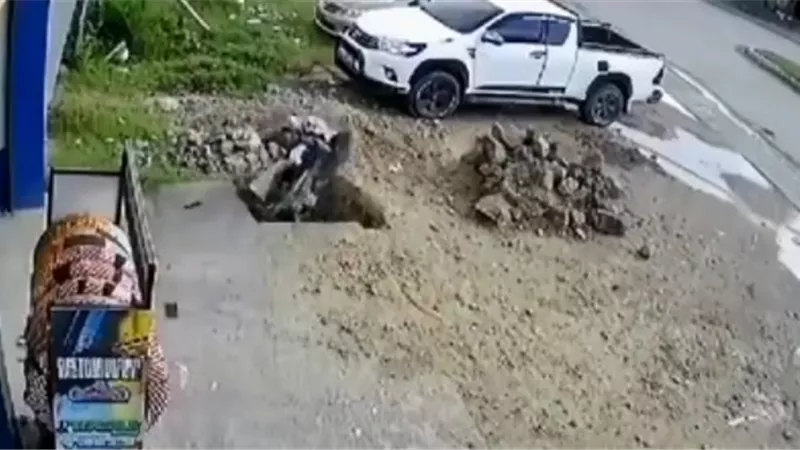 رجل يسقط بدراجته البخارية في حفرة . . فيديو