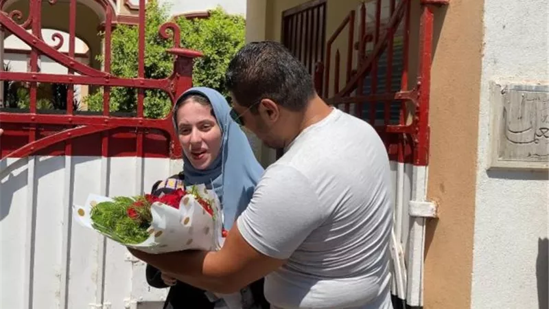 ولي أمر طالبة بأسيوط يستقبلها بالورود أمام لجنة الامتحانات