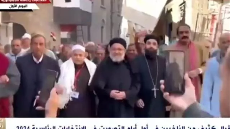 حاملين أعلام مصر.. شيخ وقسيس يقودان مسيرة انتخابية بمحافظة المنيا