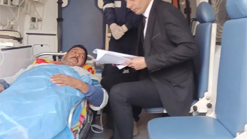 رئيس لجنة يساعد مريض علي الادلاء بصوته داخل سيارة إسعاف بالشرقية