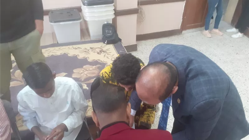رئيس لجنة الوافدين بقنا يساعد المكفوفين للإدلاء بأصواتهم